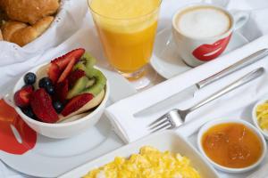 a tray of breakfast food with fruit and a drink at Admiral Motel in Santiago