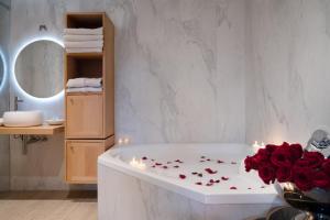 a bathroom with a tub with red roses and candles at Admiral Motel in Santiago
