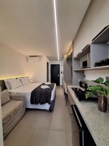 ein Hotelzimmer mit einem Bett und einer Couch in der Unterkunft Beach Haus #23 - Flat de luxo com terraço in João Pessoa