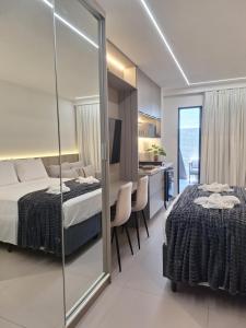 ein Schlafzimmer mit einem Bett und einem Spiegel in der Unterkunft Beach Haus #23 - Flat de luxo com terraço in João Pessoa + 35 Fotos