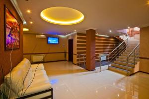 a lobby with stairs and a large yellow ceiling at Alians in Krasnodar