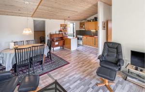 a living room with a table and chairs and a kitchen at 3 Bedroom Beautiful Home In Hørve in Hørve