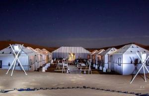 a row of tents in the desert at night at Nada luxury desert camp in Merzouga