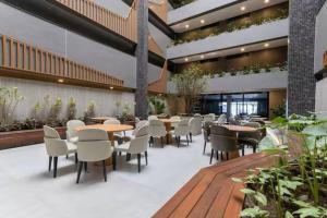 ein Restaurant mit Tischen und Stühlen in einem Gebäude in der Unterkunft Beach Haus #23 - Flat de luxo com terraço in João Pessoa