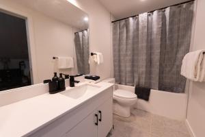 a bathroom with a sink and a toilet and a shower at Sunset Ridge- 360 Mountain Views! in Canmore