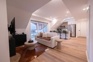 a living room with a couch and a kitchen at Sunset Ridge- 360 Mountain Views! in Canmore