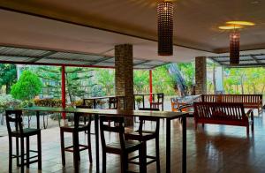 a dining room with a table and chairs and windows at La Paloma Hostal in Moyogalpa