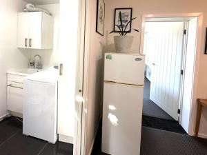 eine Küche mit einem weißen Kühlschrank und einer Spüle in der Unterkunft Kererū Garden Apartment in Dunedin