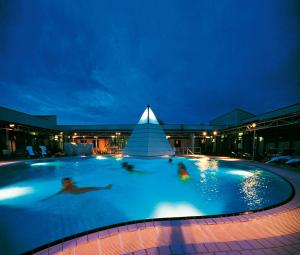 a group of people in a swimming pool at night at Gästehaus Leithen in Bad Birnbach