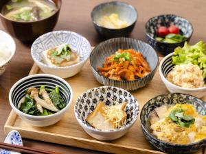a group of bowls of food on a wooden table at KOKO HOTEL Akabane Station in Tokyo