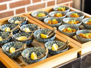a tray full of bowls of food with lemons in them at Hotel Wing International Tokyo Akabane in Tokyo +68 photos
