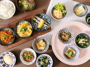 a table topped with bowls of food and plates of food at KOKO HOTEL Akabane Station in Tokyo