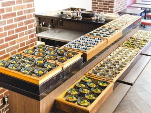 a row of trays filled with different types of food at Hotel Wing International Tokyo Akabane in Tokyo