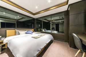 a bedroom with a large bed and a desk and a bed sidx sidx sidx sidx at Incheon Seven Hotel in Incheon