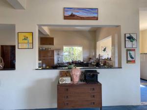 a room with a kitchen with a table and a mirror at Pousada Tigre Zen in São Thomé das Letras
