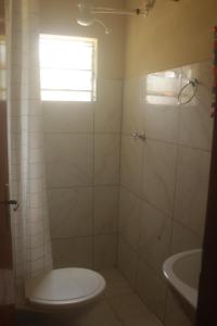 a bathroom with a toilet and a sink at Pousada Tigre Zen in São Thomé das Letras