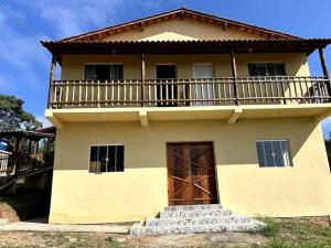 a large house with a balcony on top of it at Pousada Tigre Zen in São Thomé das Letras