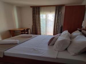 a large white bed with pillows and a window at Apartment in Ra anac near Beach Rtina in Ražanac