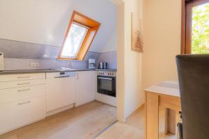 a kitchen with white cabinets and a sink and a window at Wohnung-D-306 in Böhl