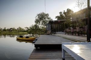 a dock with a yellow boat on the water at Amphawa Caza Platuu in Amphawa