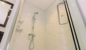 a shower with a glass door in a bathroom at A Luxury 1BR Bali Style Apartment at Branz BSD City By Travelio in Tangerang +14 photos