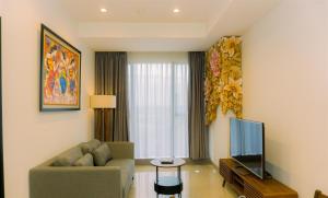 a living room with a couch and a television at A Luxury 1BR Bali Style Apartment at Branz BSD City By Travelio in Tangerang