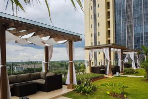 a patio with a couch and some buildings at A Luxury 1BR Bali Style Apartment at Branz BSD City By Travelio in Tangerang