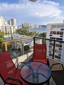 a balcony with a table and chairs and a view of a city at Apartamento VISTA AZUL RODADERO LAURELES 801 in Rodadero