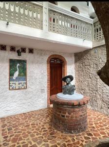 a statue sitting on top of a brick pillar in front of a building at Hotel Boutique Casa Marco in Ciénaga de Oro +5 photos