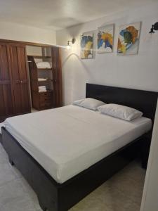 a bedroom with a large bed with white sheets at Apartamento VISTA AZUL RODADERO LAURELES 801 in Rodadero