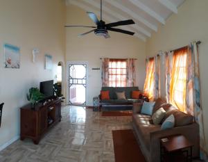 a living room with a couch and a ceiling fan at PalmVille in Carriacou