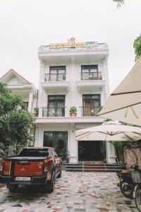 an orange truck parked in front of a white building at Tam Coc Harbor Hotel & Travel By ANMS GROUP in Ninh Binh