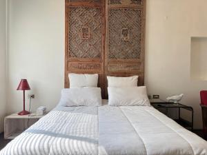 a bedroom with a large bed with a wooden headboard at Hour Roots in Tainan