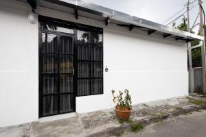 a white building with black windows and a potted plant at Casa Bella - Private Studio Ipoh - Pet allowed in Ipoh
