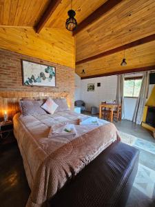 a bedroom with a large bed in a room with wooden ceilings at Chalé Sonho Diniz 2 in Monte Verde +33 photos