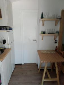 a kitchen with a white door and a wooden table at Hermosa Cabaña tinny cálida y muy equipada in Santa Ana