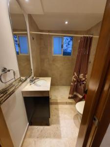 a bathroom with a sink and a toilet and a mirror at Casa Blanca Oaxtepec in Oaxtepec
