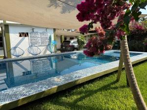 a swimming pool in a yard with a tree at hotel las olas zicatela 2 in Brisas de Zicatela
