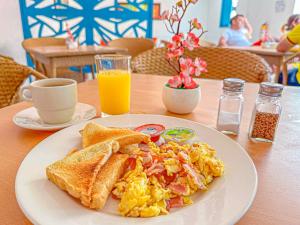 a plate of breakfast food with toast and orange juice at Hotel Casamart Rodadero in Santa Marta +82 photos