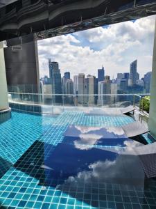 a swimming pool with a city skyline in the background at Gramercy Residences Makati by Christine Suites PH with Balcony in Manila