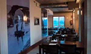 a restaurant with tables and chairs and a picture on the wall at Pons Minea in Portomarin