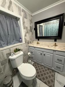 Un baño con inodoro, lavabo y espejo. en Apartment 4 people 2 bedroom Apartamento 4 personas 2 habitaciones, en Margate