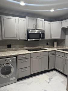 Una cocina con gabinetes blancos y un microondas. en Apartment 4 people 2 bedroom Apartamento 4 personas 2 habitaciones, en Margate