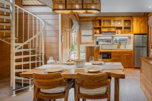 eine Küche mit einem Holztisch und Stühlen in der Unterkunft Desa La Casa Modular in Ubud