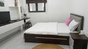 a bedroom with a bed with a desk and a television at Nguyên căn Homestay -Nhà Mẹ Khang 1 in Cu Chi
