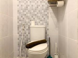 Un inodoro blanco en un baño con ducha. en Minimalist Studio Room at Tokyo Riverside PIK 2 Apartment By Travelio, en Rawalembang 16 fotos más