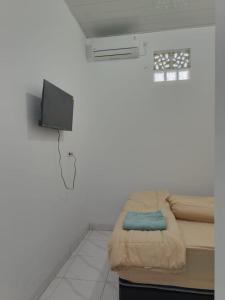 a hospital room with a bed and a tv at Avatar Homestay in Labuan Bajo