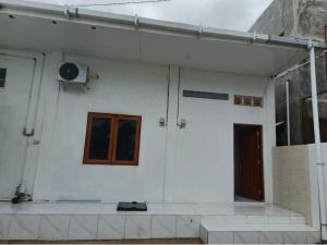 a white building with a door and a window at Avatar Homestay in Labuan Bajo +4 photos