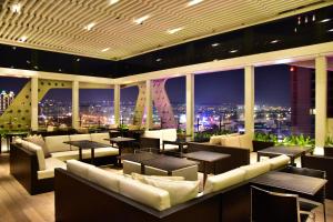 un restaurante con sofás y mesas y vistas a la ciudad en Treeart Hotel en Taichung