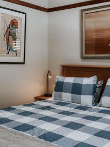 1 dormitorio con 1 cama blanca y azul a cuadros en Cathedral View - Serene Inner City Retreat, en Hobart